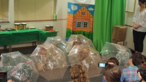 Children hiding under umbrellas on stage.